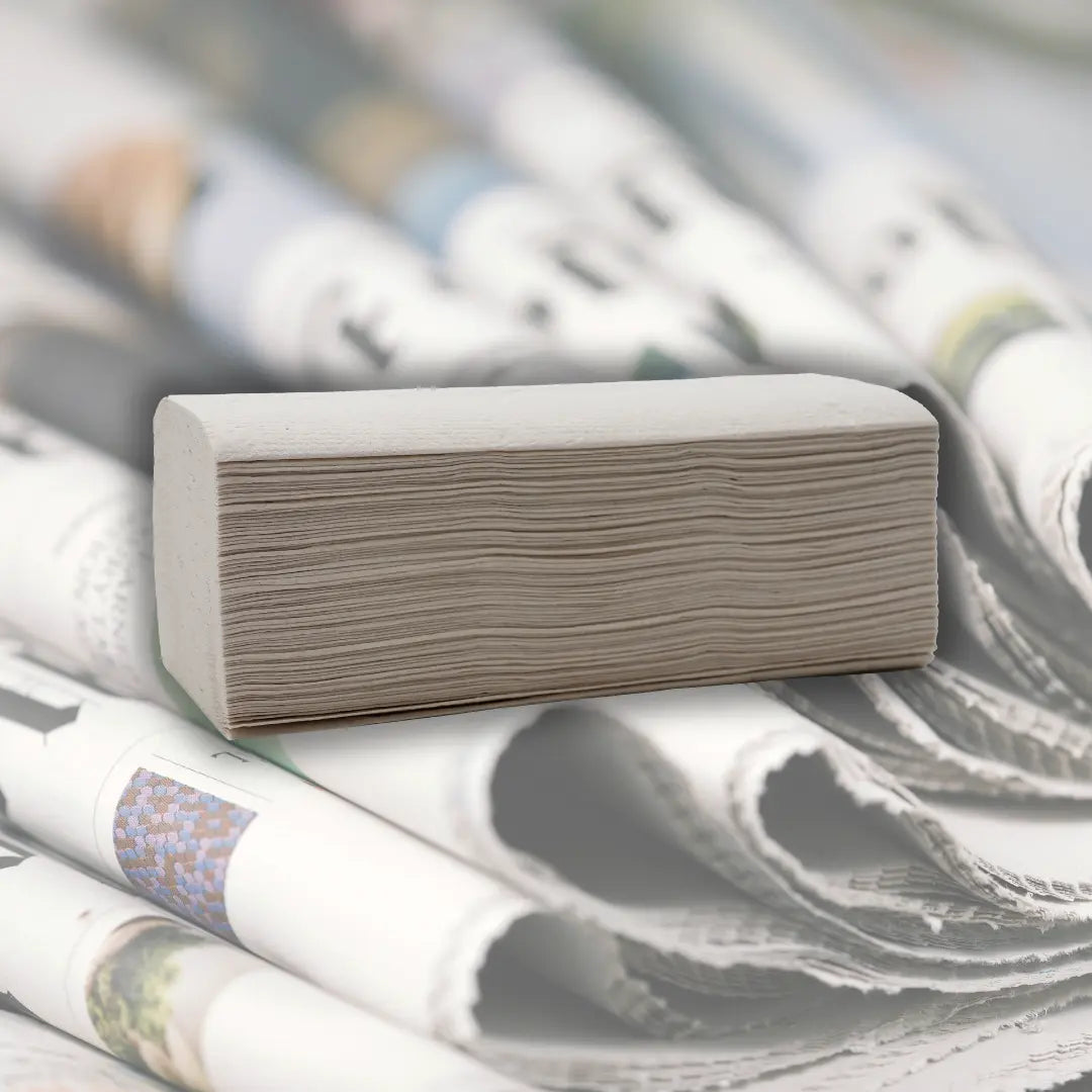 ein Päckchen Papierhandtücher vor Altpapier um Nachhaltigkeit zu verdeutlichen