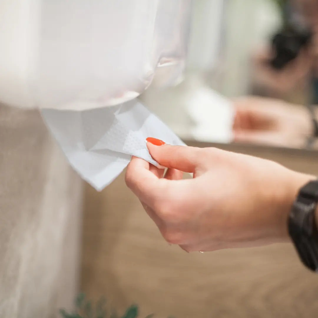 Jemand zieht Papierhandtücher aus Papierhandtuchspender